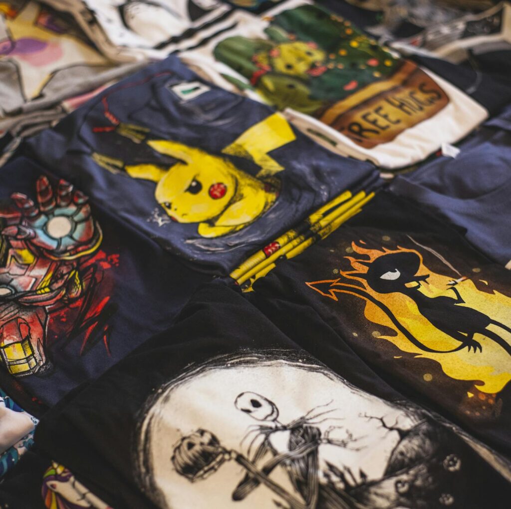 A vibrant assortment of graphic t-shirts featuring popular characters displayed in a market setting.