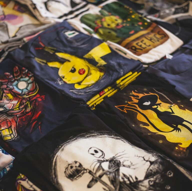 A vibrant assortment of graphic t-shirts featuring popular characters displayed in a market setting.